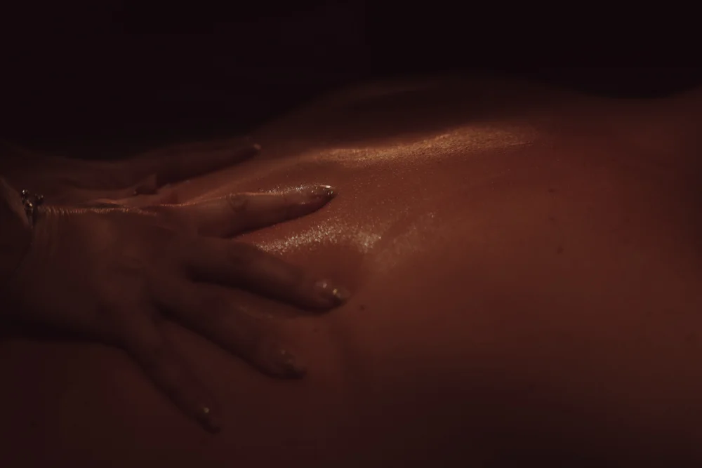 Vrouwen handen masseren mannenlijf met massageolie